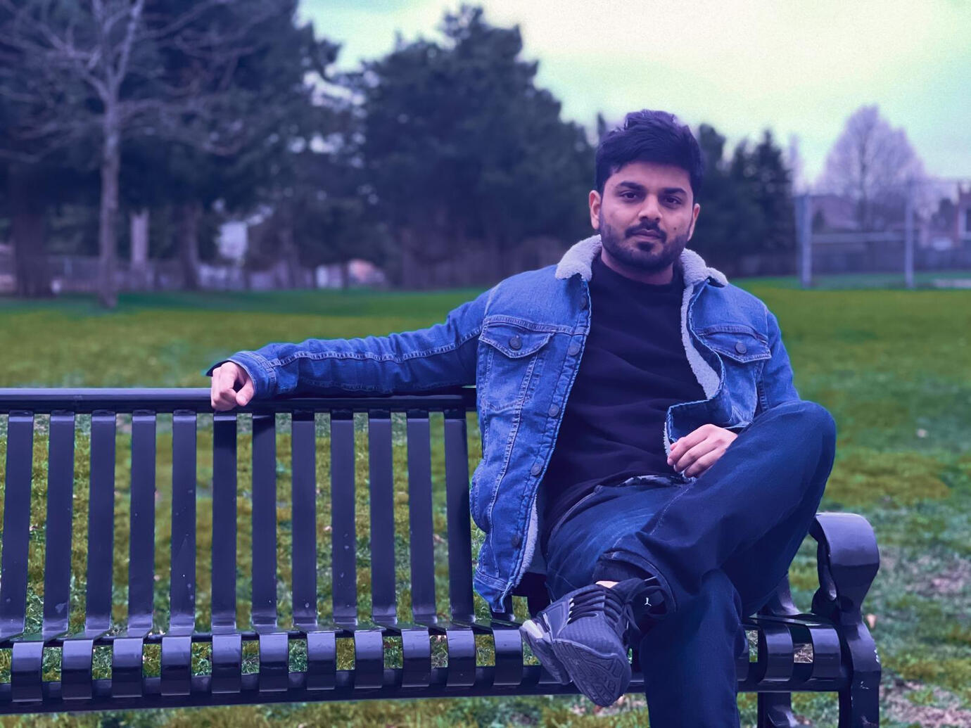 Sumit Sharma sitting on a park bench in Brampton, Canada